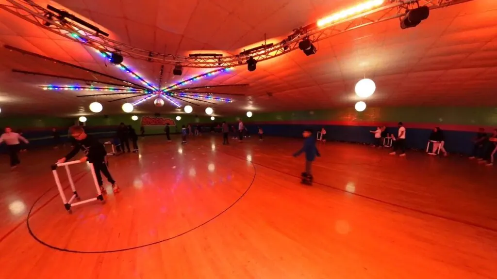 Skaters on the wooden floor, including a skater using a balance helper